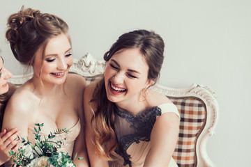 cheerful bride with her girlfriends sitting together