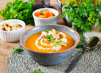 Pumpkin soup in a bowl served with parsley and croutons. Vegan soup. Thanksgiving day food. Halloween meal.