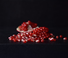 red pomegranate seeds on black background