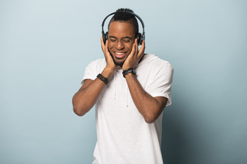 Smiling african American man listen to music in headphones