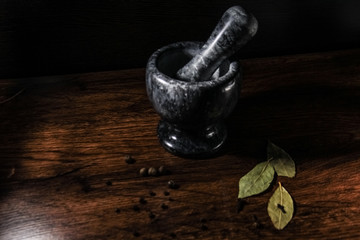 mortar and pestle with spices on wooden table