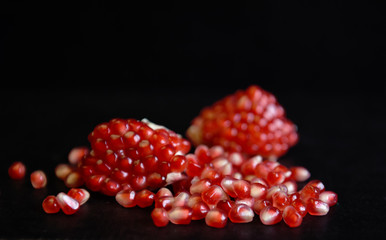 red pomegranate seeds on black background