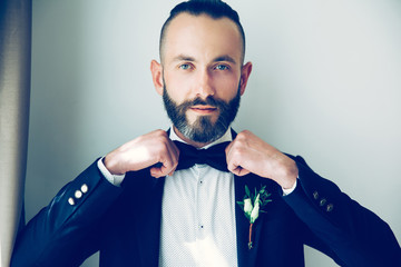 close up. confident man straightening his bow tie.