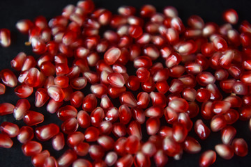 red pomegranate seeds on black background