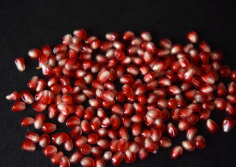 red pomegranate seeds on black background
