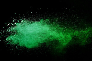 Green powder explosion on black background.