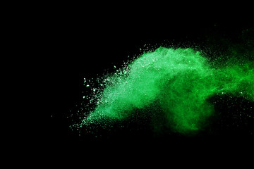 Green powder explosion on black background.