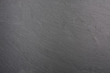 Obraz premium Dark gray background of natural slate. Texture black stone close up. Graphite backdrop macro