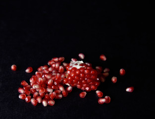 red pomegranate seeds on black background