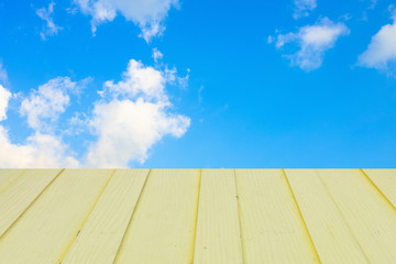 Old Wooden table with blue sky white cloud background.