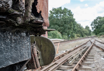 Fototapeta na wymiar Shallow focus view of an abandoned British goods train in an advanced state of decay, with a view down a railway track located on a siding in the UK.