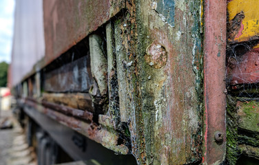 Close-up of a discarded and corroding freight wagon showing its wooden sub structure.