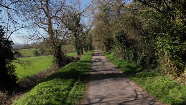 Cotswolds Wooded B-Road On Side Of Vally Zooming Out Aerial Flying Backwards 4K