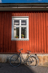 Fototapeta na wymiar Vintage bicycle in front of old red wooden house