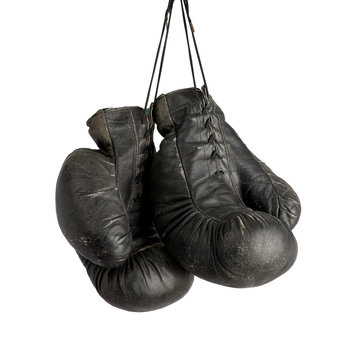 pair of very old vintage black leather boxing gloves hanging on a rope