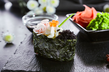 Gunkan with crab meat and masago caviar. Asian cuisine restaurant dish, menu item. Traditional oriental food, national japanese cooking. Delicious sushi, seafood on wooden platter closeup