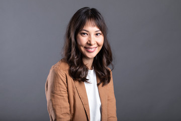 Fototapeta premium Close up young asian woman with smiley face on gray background.