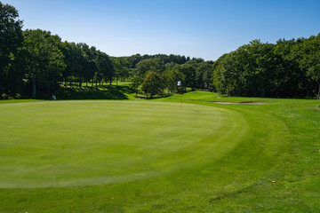 Fototapeta na wymiar Panorama View of Golf Course with beautiful putting green. Golf course with a rich green turf beautiful scenery. 