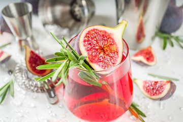 Fig autumn alcohol cocktail with cognac or liquor, rosemary, figs and honey, white marble table, with bar tools, copy space