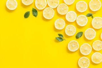 Lemon slices frame on yellow background top view copy space