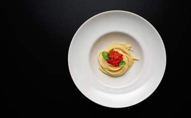 Top view of white plate with spaghetti on modern background