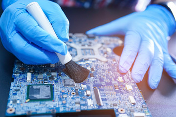 Asian Technician repair and cleaning dirty dust micro circuit main board computer electronic...
