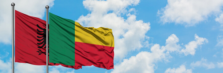 Albania and Benin flag waving in the wind against white cloudy blue sky together. Diplomacy concept, international relations.