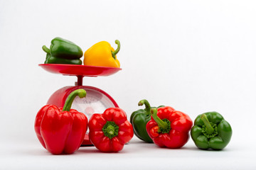Sweet peppers on red scales market concept on the white background isolated