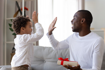 Happy ethnic dad give high five thanking little son