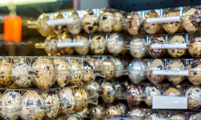 raw quail eggs in plastic at shop