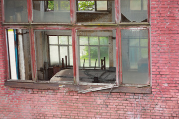 The building of an abandoned factory with broken windows.