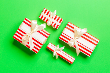 Fototapeta premium Gift box with yellow bow for Christmas or New Year day on green background, top view