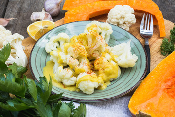 Steamed cauliflower with sauce and pumpkin and greenery