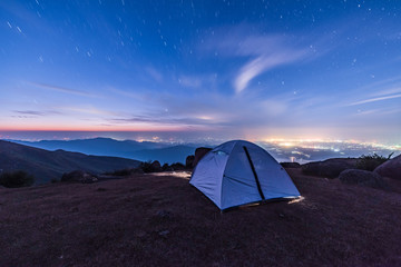 Tourist hikers tent in mountains at night with stars in the sky  © hrui