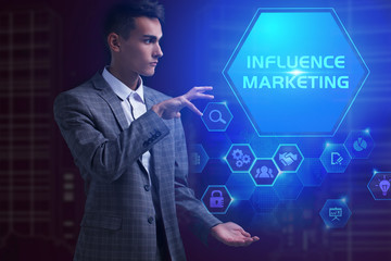 The concept of business, technology, the Internet and the network. A young entrepreneur working on a virtual screen of the future and sees the inscription: Influence marketing