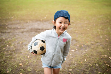サッカーボールを抱えた笑顔の女の子