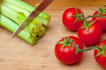 Celery and tomatoes on a cutting board