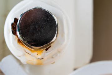 Point of leakage. Bottom plug of a central heating radiator. Oxidation on a frame.