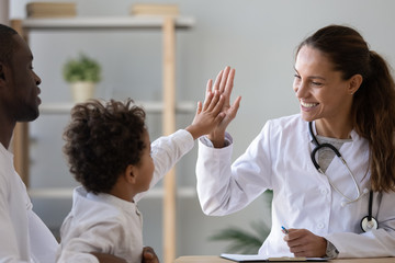 Smiling female doctor give high five to little biracial patient - Powered by Adobe
