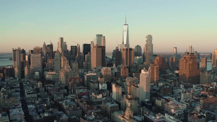 Flying towards Lower Manhattan Downtown business district at sunrise, skyline of New York with morning light