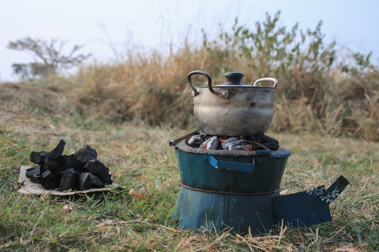 Traditional cooking charcoal and potbelly stove in Africa on nature in a pan.