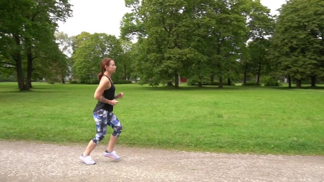 slow motion-woman running in green park