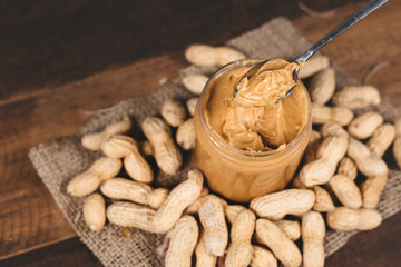 Peanut butter,groundnut and spoon on a wooden table. Concept of breakfast food and peanut butter lover