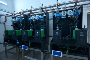 Dosing pumps, tubes, manometers set in the dosing systems hall of the water pumping station
