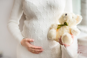 pregnant woman holding a teddy bear