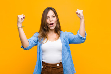 young pretty woman celebrating an unbelievable success like a winner, looking excited and happy...