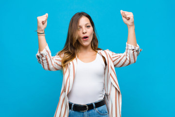 young pretty woman celebrating an unbelievable success like a winner, looking excited and happy...