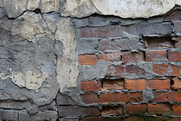Old wall with cracked stucco and bricks. Stone background.