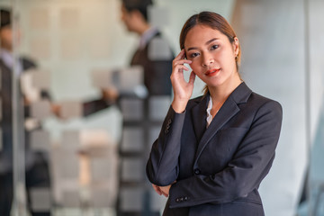 Portrait of young beautiful business woman in the office. Crossed arms	