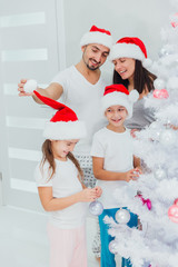 Obraz premium Family decorating beautiful Christmas tree in room
